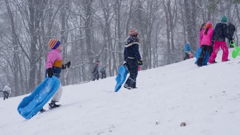 Chicas-Jóvenes-Subiendo-Una-Colina-En-Medio-De-Nevadas-En-Bruselas,-Bélgica---Cámara-Lenta