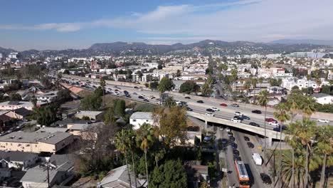 East-Hollywood,-Los-Angeles,-Drone-Shot-of-US-101-Highway-Traffic,-Buildings-and-Griffith-Observatory