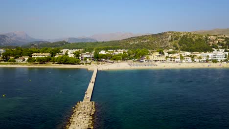 Playa-del-port-de-pollenca-beach-in-mallorca-on-a-sunny-day,-clear-blue-waters,-aerial-view,-Spain,-in-the-Mediterranean-Sea