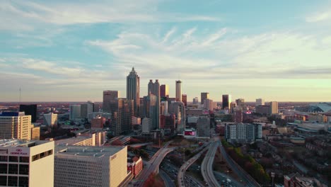 Luftaufnahme-Der-Skyline-Von-Atlanta-Bei-Sonnenuntergang-Mit-Städtischen-Wolkenkratzern-Und-Stark-Befahrenen-Autobahnen