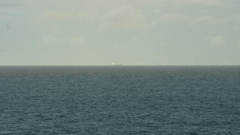 A-Cargo-Ship-Seen-in-the-Distance-on-the-Open-Ocean---Wide-Shot