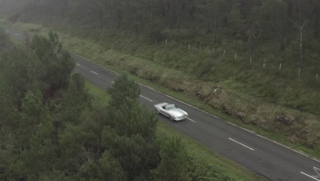 Vintage-car-driving-along-road-crossing-Spanish-Pyrenees,-Spain