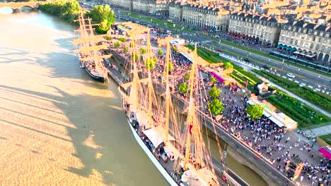 Vintage-sail-ships-with-large-crowds-by-the-Garonne-river,-Aerial-overhead-view