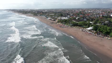 Aerial-view-of-surfers-and-beachgoers-at-famous-surf-destination-Canggu-beach-in-Bali,-Indonesia