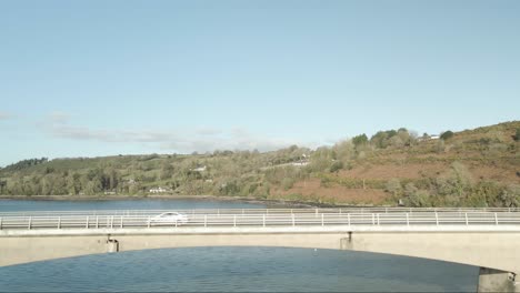 Sunlit-Youghal-Bridge-over-River-Blackwater,-lush-Irish-countryside-backdrop,-clear-day