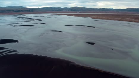 Aerial-establishing-shot-of-Ölfusá-river-in-Iceland-with-braids-and-colorful-transparent-water