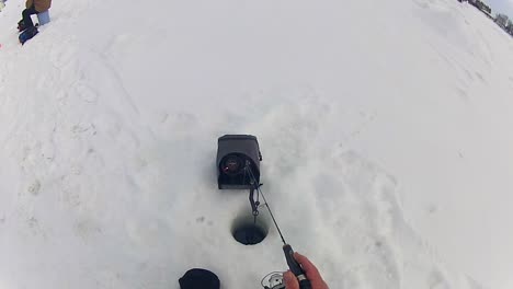 A-Man-Employing-a-Flasher-While-Ice-Fishing---High-Angle-Shot
