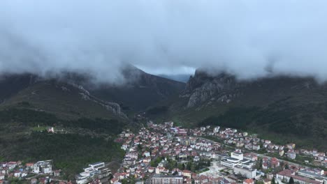 Ariel-shot-of-a-small-town-and-mountain-and-clouds