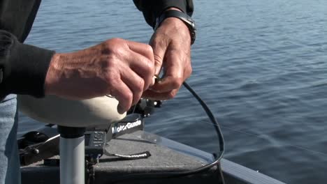 Pescador-En-Barco-Poniendo-Sanguijuela-En-Anzuelo-De-Pesca.