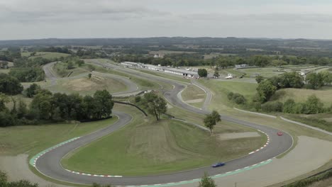 Vintage-car-racing-on-Pau-Arnos-circuit-as-seen-from-drone-flying