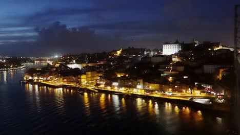 People-strolling-at-night-by-Luis-I-Bridge-over-Douro-River-in-Porto-city