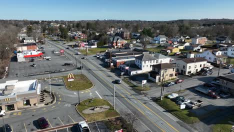 Drone-flyover-american-town-with-Mc-Donald's-and-parking-area-at-sunny-day