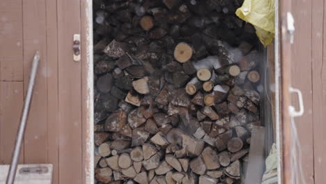 chopped-wood-logs,-firewood-stock,-beautiful-scenic-winter-concept-with-snowflakes-falling