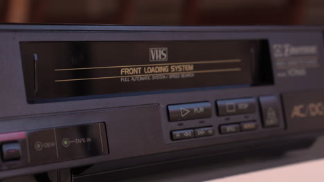 Inserting-VHS-Video-Tape-in-VCR-Player,-Close-Up