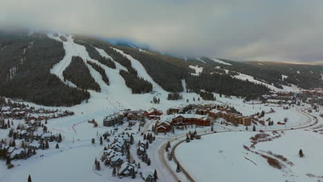 Foggy-cloud-layers-winter-snowy-early-morning-sunrise-aerial-drone-Copper-Mountain-Colorado-ski-resort-village-Eagle-Flyer-Super-Bee-lift-Ikon-Epic-Pass-cars-on-road-snowboarding-ski-forward