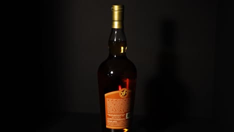 Weller-Single-Barrel-Orange-Label-Kentucky-Straight-Bourbon-Whiskey,-Der-Sich-Im-Vordergrund-Um-360-Grad-Dreht,-Mit-Einem-Dunkelschwarzen-Hintergrund,-Frankfort-Kentucky-Bourbon-Trail,-Getränk-Statisch