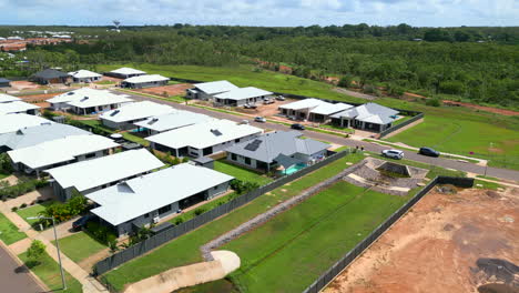 Aerial-drone-of-New-House-Build-as-Car-Drives-Past,-Zuccoli-Northern-Territory-Australia,-Pullback-Location-Establishing