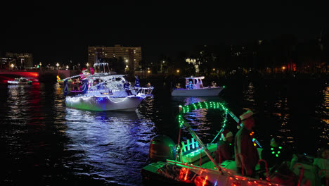 Gente-Celebrando-Las-Fiestas-Y-Disfrazada-En-Un-Bote-Flotante-En-El-Desfile-De-Botes-De-Navidad-En-Tampa,-Florida,-Toma-Nocturna