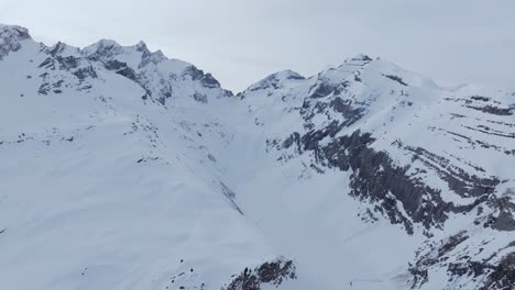 Luftaufnahme-Einer-Drohne,-Die-Die-Silhouette-Einer-Schneebedeckten-Bergkette-Bei-Sonnenaufgang-Einfängt