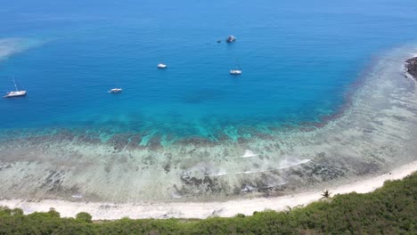 Filmische-Luftaufnahme-Eines-Paradiesischen-Strandes-Mit-Kristallklaren-Wellen,-Die-Gegen-Das-Ufer-Schlagen