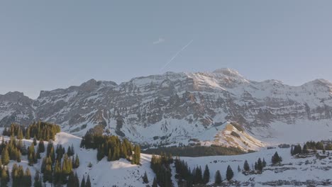 Drohnenaufnahmen-Des-Sonnenaufgangs-über-Der-Silhouette-Einer-Schneebedeckten-Bergkette