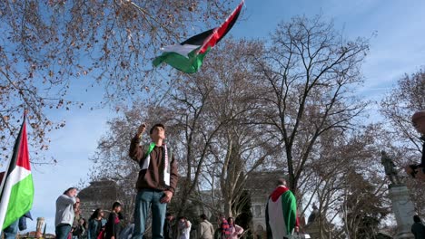 Ein-Junger-Demonstrant-Schwenkt-Während-Eines-Solidaritätsmarsches-Mit-Palästina-Eine-Palästinensische-Flagge