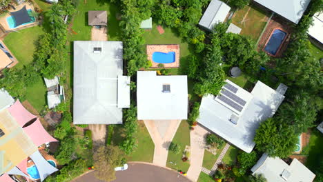 Drone-Aéreo-De-Un-Gran-Bloque-Residencial-Tropical-Con-Una-Enorme-Casa-Y-Piscina-En-Una-Calle-Curva,-Entrada-Triangular,-Vista-De-Pájaro-De-Arriba-Hacia-Abajo-Girar-Descender