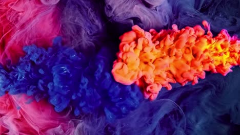 Orange,-blue-and-pink-ink-drops-mixing-in-water