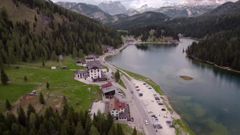 Lake-Misurina-aerial-over-restaurants-toward-mountains,-Dolomites