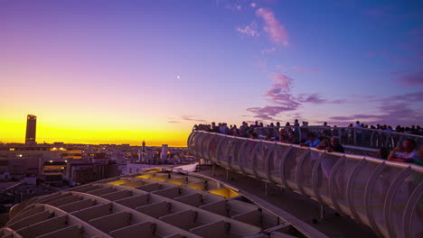 Zeitraffer-Mit-Blick-Auf-Die-Setas-De-Sevilla-In-Spanien,-Wo-Sich-Touristen-Versammeln-Und-Den-Sonnenuntergang-Beobachten,-Bei-Dem-Der-Himmel-Sich-Gelb-Und-Violett-Färbt