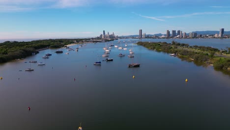 Aerial-views-moving-South-towards-Surfers-Paradise,-over-yachts-on-anchor-and-the-Broadwater-on-the-Gold-Coast,-Australia