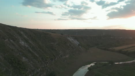 "Golden-Hour-Glance:-A-Breathtaking-Drone-Expedition-Capturing-the-Majestic-Orheiul-Vechi,-Moldova,-as-the-Sun-Sets-Behind-the-Iconic-Monastery-on-the-Hill,-Illuminating-the-Serene-River-Raut-Below