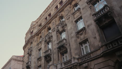 Fachada-De-Un-Edificio-En-Budapest-Hungría,-Hermosa-Arquitectura,-Antiguo-Edificio-Residencial-En-La-Ciudad,-Exterior-De-Un-Antiguo-Edificio-De-Apartamentos-Renovado-De-Varios-Pisos,-Grandes-Ventanales,-Balcón,-Europa-Urbana