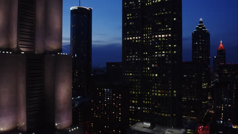 Toma-De-Drones-De-Los-Famosos-Rascacielos-De-Atlanta,-Georgia,-Iluminados-Con-Luz-Nocturna-Bajo-El-Cielo-Crepuscular,-EE.UU.