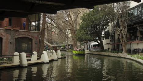 Tourist-Boat-Passes-Under-Bridge-on-San-Antonio's-River-Walk-in-Texas