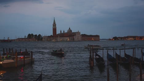 Vista-Panorámica-De-Venecia-Al-Atardecer-Desde-El-Muelle-Con-Varios-Barcos-Y-Góndolas,-Italia