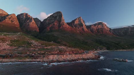 Victoria-Road-With-Twelve-Apostles-Mountains-In-Cape-Town,-South-Africa---Aerial-Drone-Shot