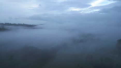 drone-shot-focusing-on-the-mist-and-clouds-that-formed-above-the-Windermere-Lake,-the-largest-lake-in-England-located-in-the-county-of-Cumbria-in-Great-Britain