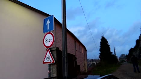 Right-pan-reveals-woman-walking-to-dusty-path-between-parked-cars-at-night