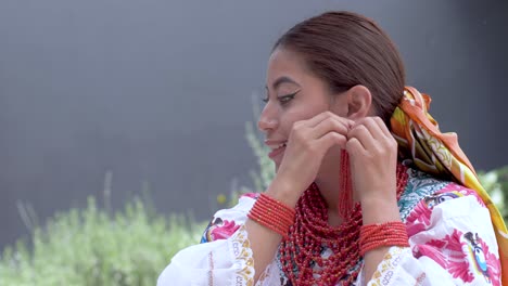 Cinematic-clip-of-a-young-brunette-latin-girl-wearing-the-traditional-outfit-named-Cayambeñas-putting-on-her-earings-and-smiling