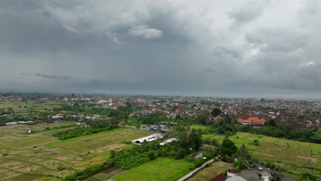 Rice-fields-with-Bali-city-center-in-background,-Indonesia