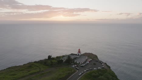Drone-shot-of-a-lighthouse-on-a-hill-and-view-to-the-sea