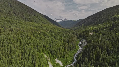 Whistler-BC-Canada-Aerial-v7-flyover-the-creek-capturing-verdant-valleys-covered-in-dense-coniferous-forest,-towering-trees-and-gondola-crossing-mountain-peaks---Shot-with-Mavic-3-Pro-Cine---July-2023