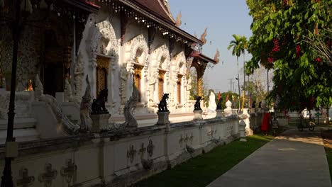 Monk-cleaning-temple-grounds-with-temple-building-in-background