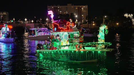 Gente-Divirtiéndose-Y-Celebrando-Las-Fiestas-Mientras-Lanzan-Cuentas-A-Una-Multitud-Mientras-Están-En-Un-Bote-Flotante-En-El-Desfile-De-Botes-De-Navidad-En-Tampa,-Florida,-Toma-Nocturna
