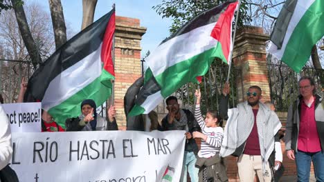 Un-Grupo-De-Manifestantes-Sostienen-Una-Pancarta-Y-Ondean-Banderas-Durante-Una-Marcha-En-Solidaridad-Con-Palestina.