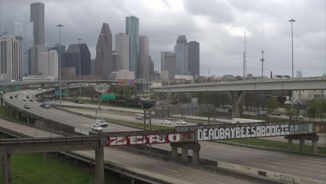 Descending-drone-shot-of-downtown-Houston-cityscape-that-reveals-a-large-alligator-in-the-Buffalo-Bayou