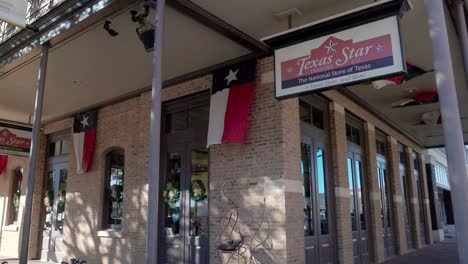 Texas-Star-Store-In-Abilene,-Texas-Mit-Wehenden-Flaggen-Der-Bundesstaaten-Texas-An-Einem-Windigen-Tag-Und-Stabiler-Videoaufnahme