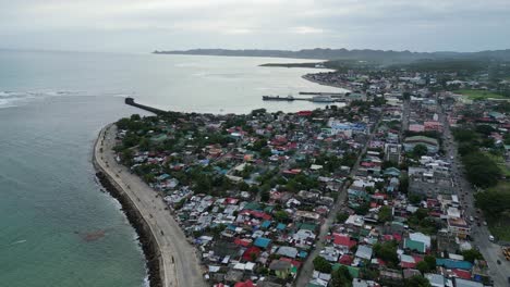 Scenic-aerial-view-of-coastal-island-town-with-idyllic-ocean-bay,-busy-streets-and-houses