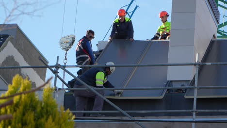 Arbeiter-Montieren-Solarmodule-Als-Dach-Auf-Einem-Haus